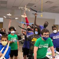 Campers take a silly photo with their completed airplanes